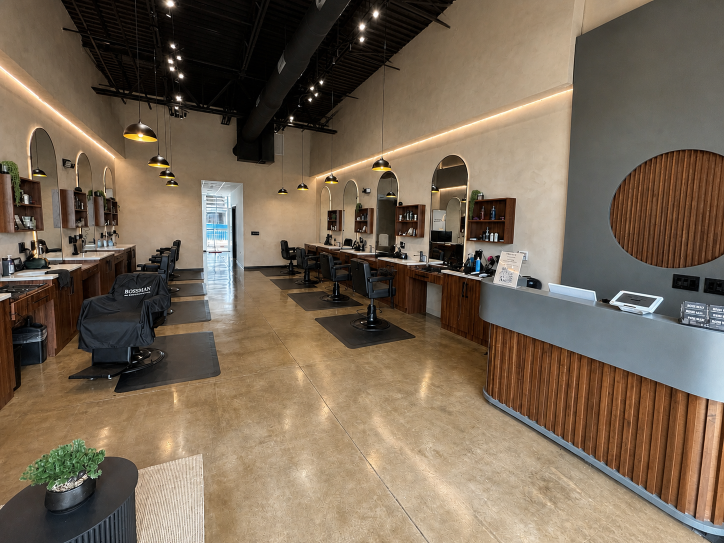 Barbershop interior with black barber chairs, arched mirrors, and pendant lights