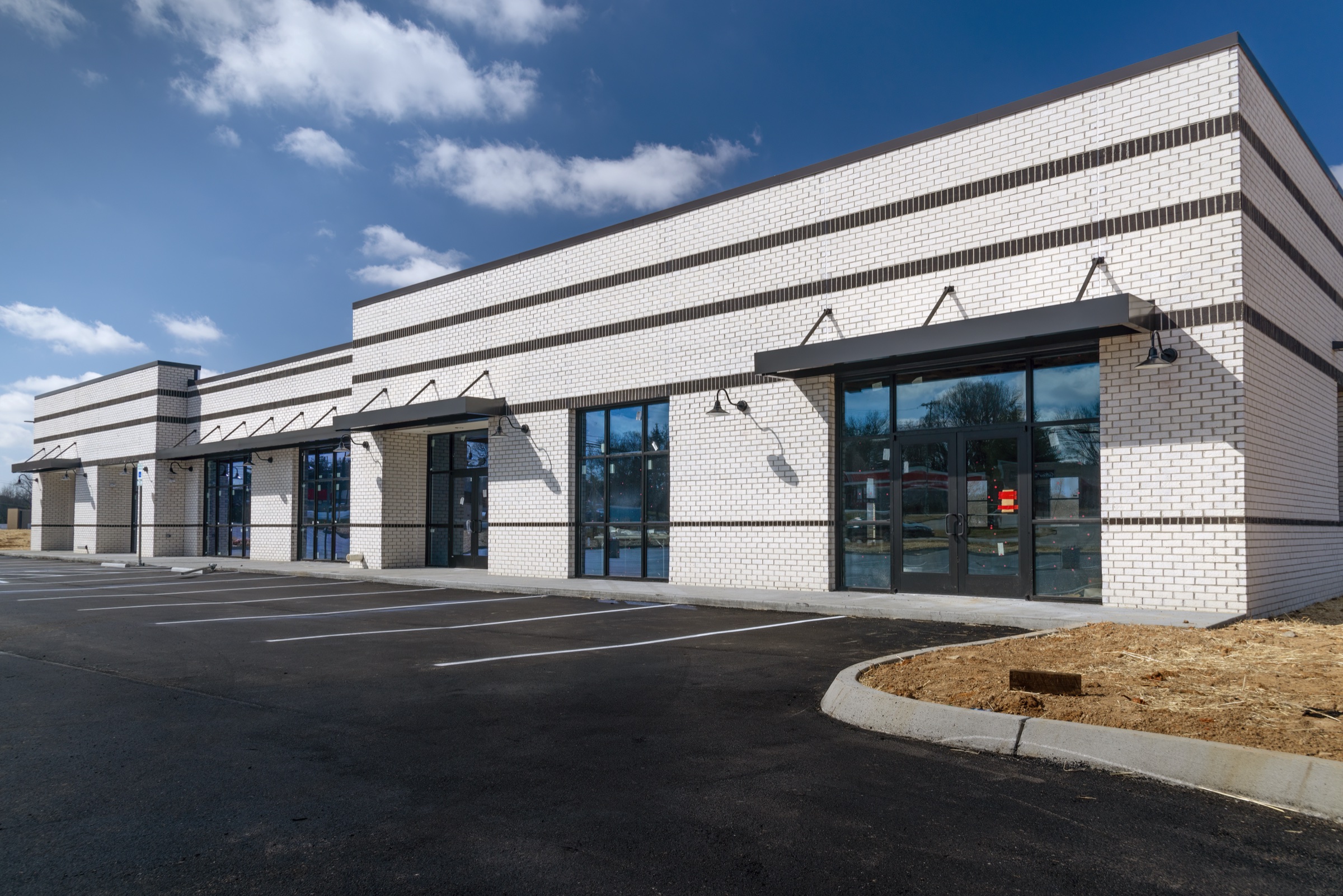 New retail strip building with white brick exterior and glass storefronts in Indian Land, South Carolina